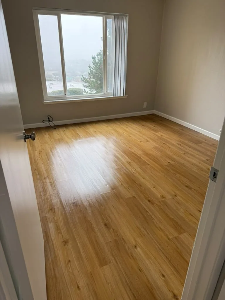 Empty, clean bedroom with shiny wood floor